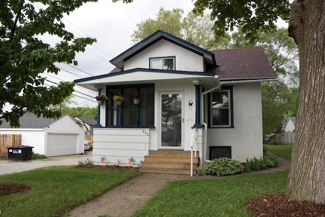 232 Harrison Ave, Waukesha, WI 53186 - bungalow-style house featuring entry steps, a detached garage, an outbuilding, a shingled roof, and a front yard