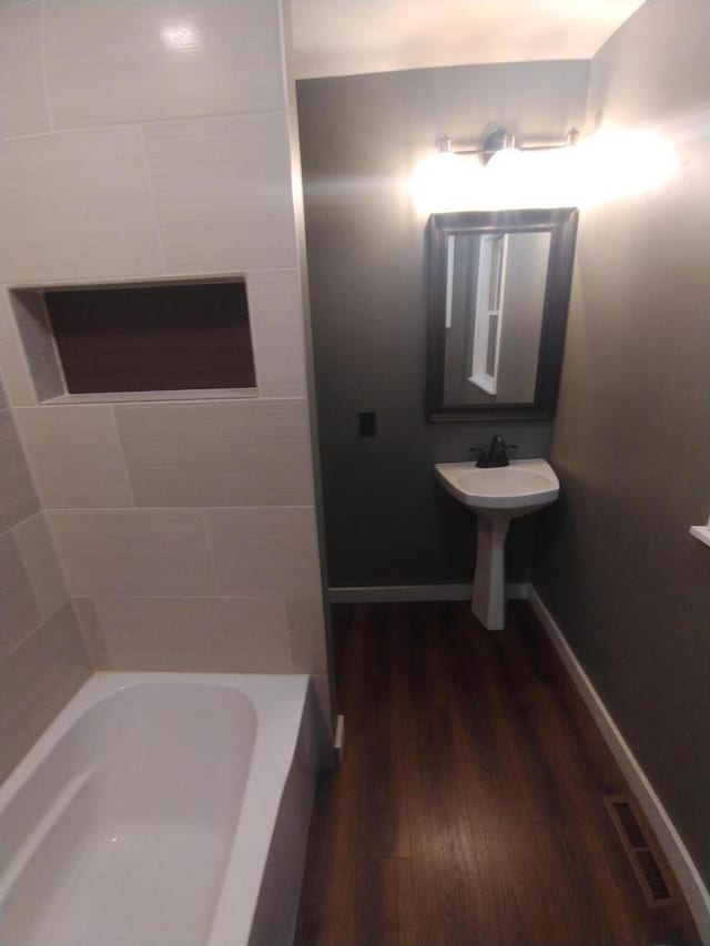 232 Harrison Ave, Waukesha, WI 53186 - full bathroom featuring a bathtub, wood finished floors, baseboards, and a sink