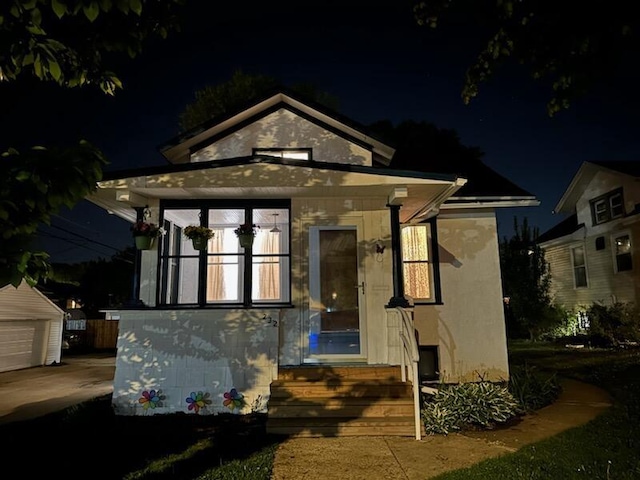 232 Harrison Ave, Waukesha, WI 53186 - back of house at night with entry steps, an outdoor structure, and a detached garage