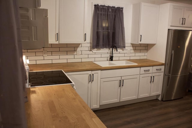 232 Harrison Ave, Waukesha, WI 53186 - kitchen with wood counters, freestanding refrigerator, a sink, white cabinets, and decorative backsplash