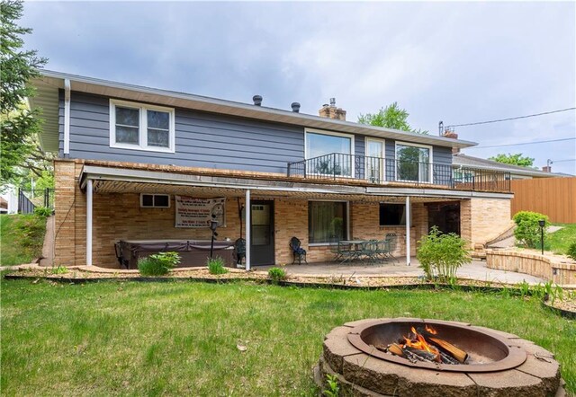 2126 Hogeboom Ave, Eau Claire, WI 54701 - rear view of property with a hot tub, a fire pit, a patio area, a balcony, and brick siding