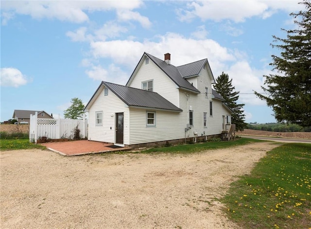4190 County Road P, Spring Valley, WI 54767 - rear view of house with metal roof, a patio area, a chimney, and fence
