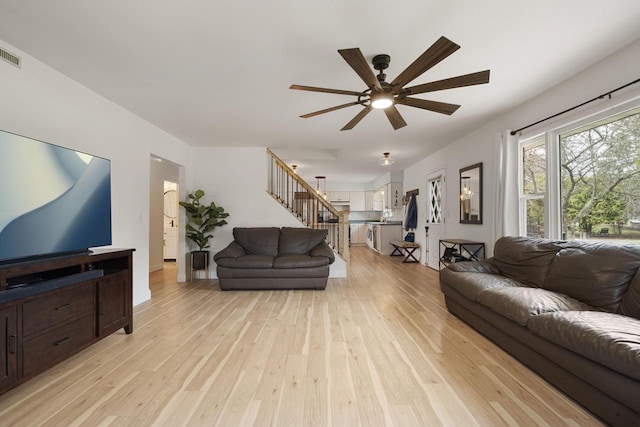 115 Glenwood Dr, Williams Bay, WI 53191 - living room featuring stairs, a ceiling fan, light wood finished floors, and baseboards