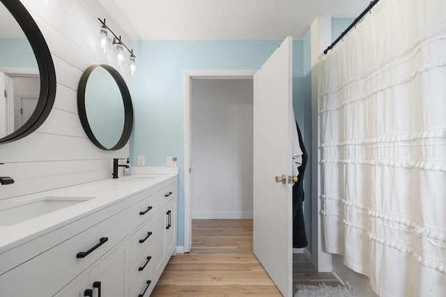115 Glenwood Dr, Williams Bay, WI 53191 - bathroom featuring wood finished floors, baseboards, and double vanity