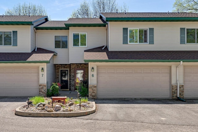 1204 Lakeview Dr # 6, Tomah, WI 54660 - view of property featuring stone siding, a garage, and a shingled roof