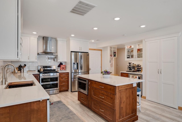 1204 Lakeview Dr # 6, Tomah, WI 54660 - kitchen featuring wall chimney exhaust hood, stainless steel appliances, a sink, white cabinets, and light countertops