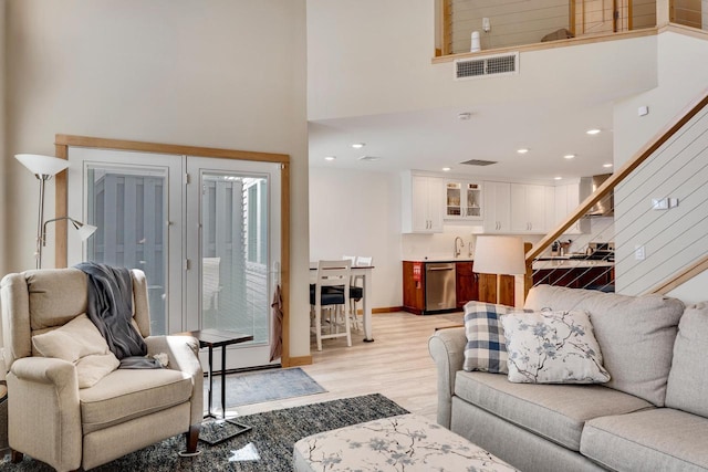 1204 Lakeview Dr # 6, Tomah, WI 54660 - living area with stairway, light wood-style floors, a high ceiling, and recessed lighting