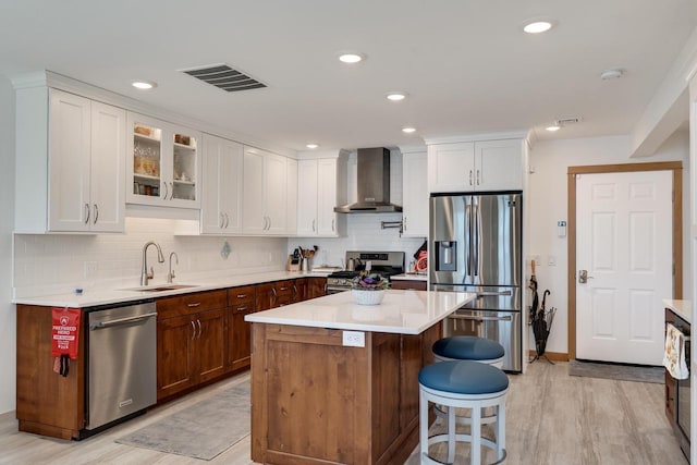 1204 Lakeview Dr # 6, Tomah, WI 54660 - kitchen with stainless steel appliances, wall chimney range hood, a sink, white cabinets, and light countertops