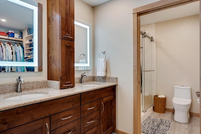 1204 Lakeview Dr # 6, Tomah, WI 54660 - full bathroom featuring a shower stall, toilet, double vanity, a spacious closet, and baseboards