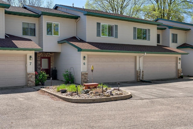 1204 Lakeview Dr # 6, Tomah, WI 54660 - view of property with an attached garage, asphalt driveway, and roof with shingles