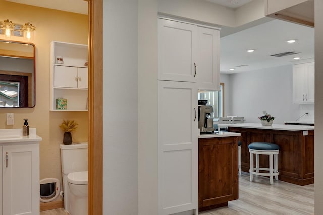 1204 Lakeview Dr # 6, Tomah, WI 54660 - bathroom featuring wood finished floors, vanity, toilet, and recessed lighting
