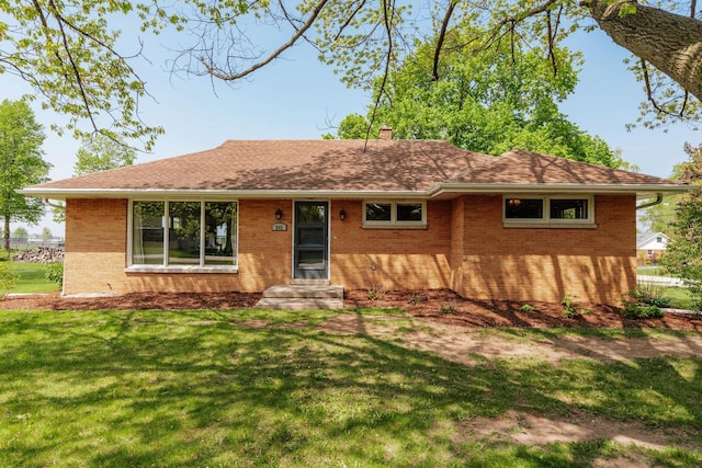 ranch-style house with brick siding, a front lawn, and a chimney