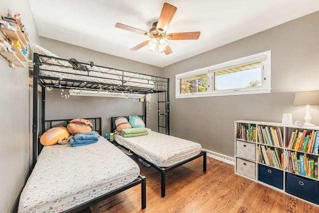 bedroom with wood finished floors, baseboards, and a ceiling fan