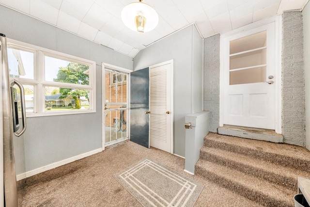 foyer featuring carpet and baseboards