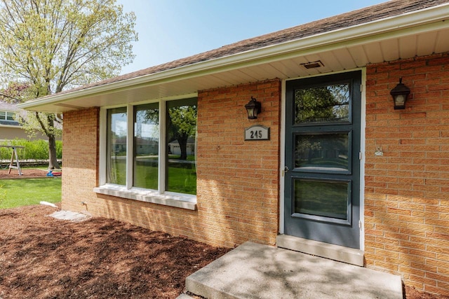 property entrance featuring brick siding