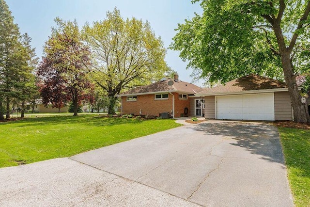 view of front of house with asphalt driveway, a front lawn, and an attached garage