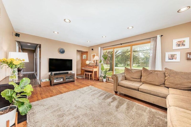 living room featuring wood finished floors, recessed lighting, and baseboards