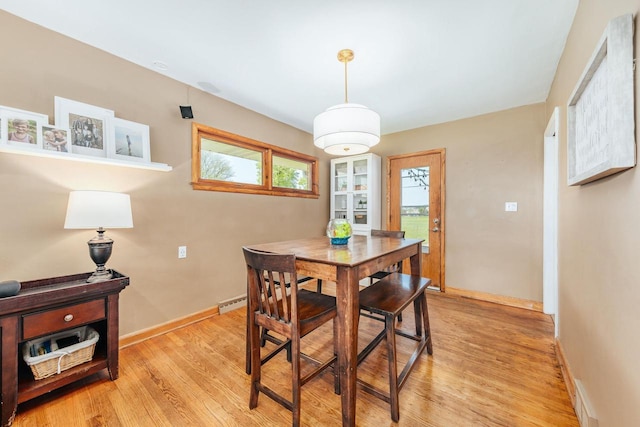 dining space with baseboards and light wood-style floors