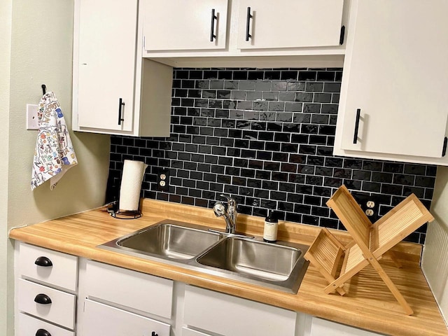 7 Oak Trl, Wisconsin Dells, WI 53965 - kitchen with a sink, decorative backsplash, and white cabinets