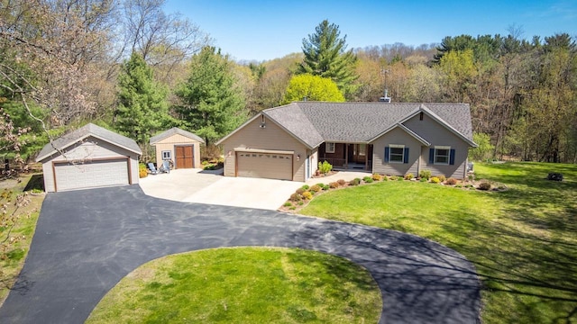 N4404 Pine Dr, Montello, WI 53949 - single story home with a front yard, an outbuilding, a view of trees, and a detached garage
