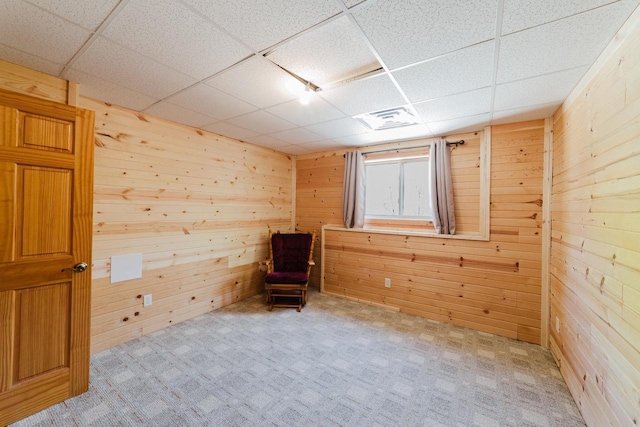 N4404 Pine Dr, Montello, WI 53949 - empty room featuring a paneled ceiling, wooden walls, and light colored carpet