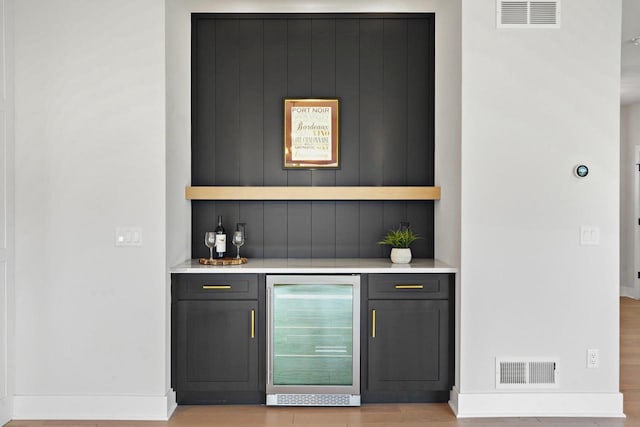 815 Steven Vw, Waunakee, WI 53597 - indoor dry bar featuring beverage cooler, baseboards, and light wood-style flooring