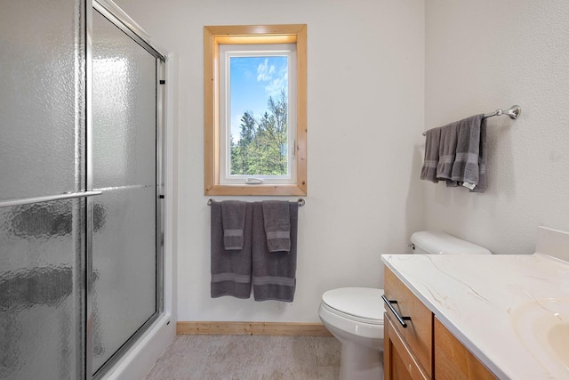 12450 Nixon Rd, Minocqua, WI 54548 - full bathroom featuring a stall shower, vanity, baseboards, and toilet