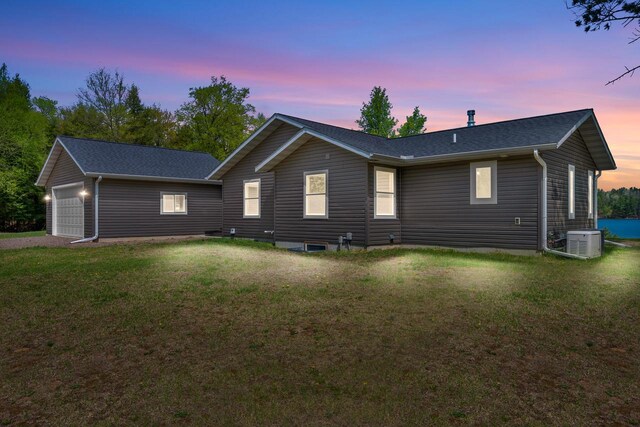 12450 Nixon Rd, Minocqua, WI 54548 - rear view of property with central air condition unit, a yard, and roof with shingles