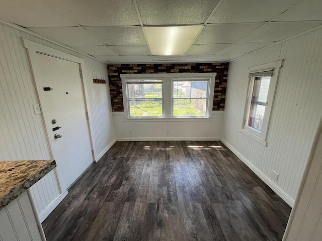 923 E Clarke St, Milwaukee, WI 53212 - unfurnished dining area with a drop ceiling, dark wood-type flooring, baseboards, and wood walls