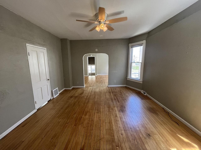 923 E Clarke St, Milwaukee, WI 53212 - empty room featuring arched walkways, a ceiling fan, hardwood / wood-style floors, and baseboards