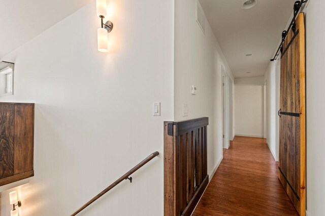 450 Lake Ave, Montello, WI 53949 - hallway with an upstairs landing, wood finished floors, a barn door, and baseboards