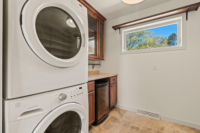 450 Lake Ave, Montello, WI 53949 - laundry area featuring stacked washer and clothes dryer, cabinet space, and baseboards