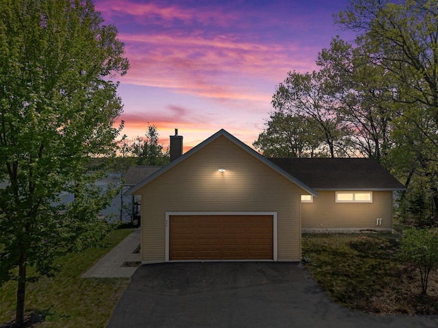 450 Lake Ave, Montello, WI 53949 - view of front facade with asphalt driveway, a chimney, and a garage