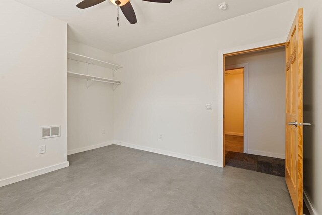 450 Lake Ave, Montello, WI 53949 - unfurnished bedroom with concrete floors, ceiling fan, baseboards, and a closet
