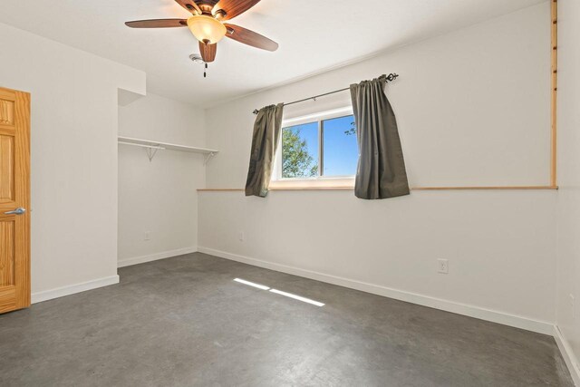 450 Lake Ave, Montello, WI 53949 - unfurnished bedroom featuring finished concrete floors, baseboards, a closet, and a ceiling fan