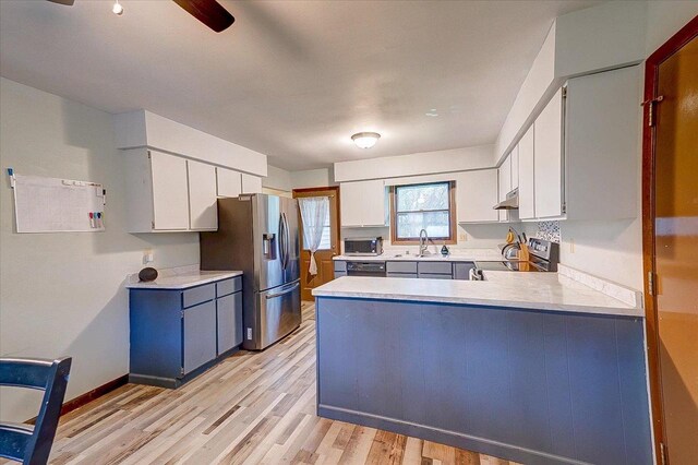 864 Suellen Ln, Portage, WI 53901 - kitchen featuring appliances with stainless steel finishes, a peninsula, light countertops, light wood-style flooring, and white cabinets