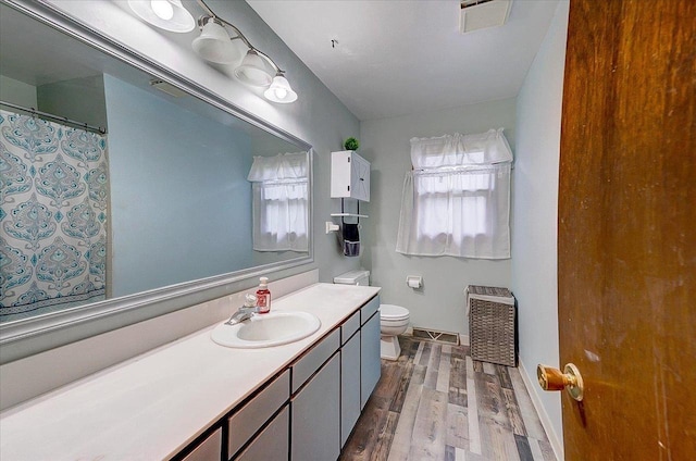 864 Suellen Ln, Portage, WI 53901 - full bathroom featuring wood finished floors, toilet, vanity, heating unit, and baseboards