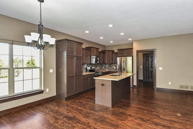 494 Woodfield Cir, Waterford, WI 53185 - kitchen with appliances with stainless steel finishes, a sink, dark brown cabinets, a chandelier, and dark wood-type flooring