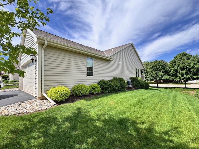 494 Woodfield Cir, Waterford, WI 53185 - view of side of property featuring a yard, an attached garage, driveway, and a shingled roof
