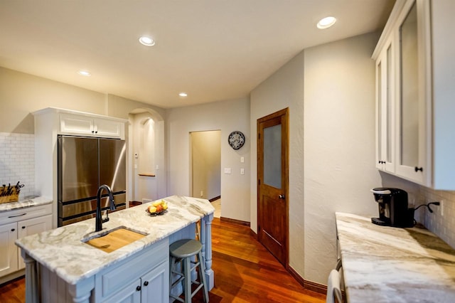 870 Eden Ct, Menasha, WI 54956 - kitchen with freestanding refrigerator, backsplash, white cabinets, and recessed lighting