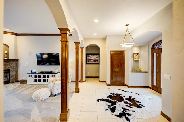 870 Eden Ct, Menasha, WI 54956 - entryway featuring arched walkways, decorative columns, baseboards, a tile fireplace, and light tile patterned floors