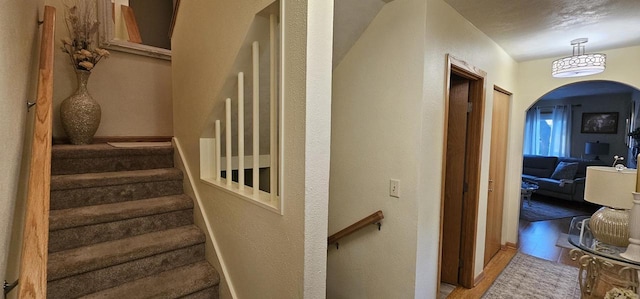 26 Waunona Woods Ct, Madison, WI 53713 - stairway with arched walkways, wood finished floors, and a textured wall