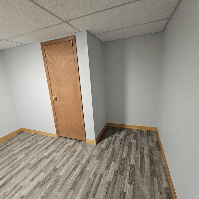 26 Waunona Woods Ct, Madison, WI 53713 - empty room with wood finished floors, a paneled ceiling, and baseboards