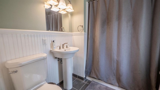 W7660 State Road 21, Wautoma, WI 54982 - bathroom featuring a wainscoted wall, toilet, tile patterned flooring, a sink, and a shower with shower curtain