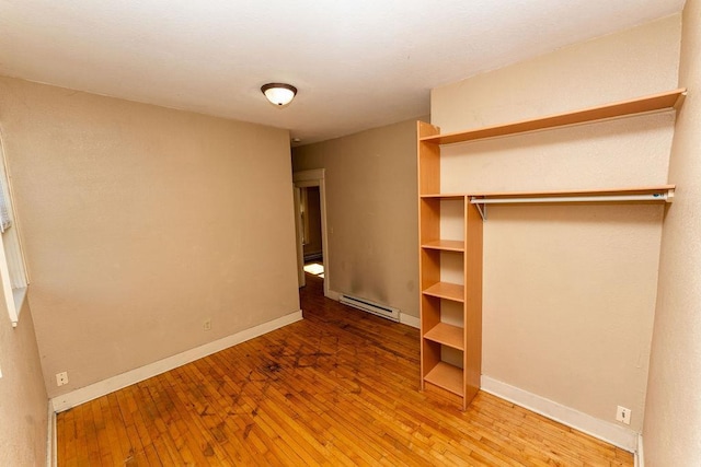 306 Wisconsin St, Oshkosh, WI 54901 - unfurnished bedroom featuring hardwood / wood-style flooring, baseboards, a baseboard radiator, and a closet