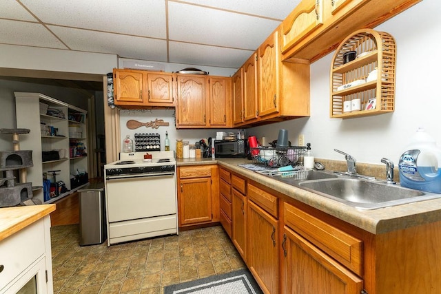 306 Wisconsin St, Oshkosh, WI 54901 - kitchen with electric range, a sink, a drop ceiling, light countertops, and brown cabinetry
