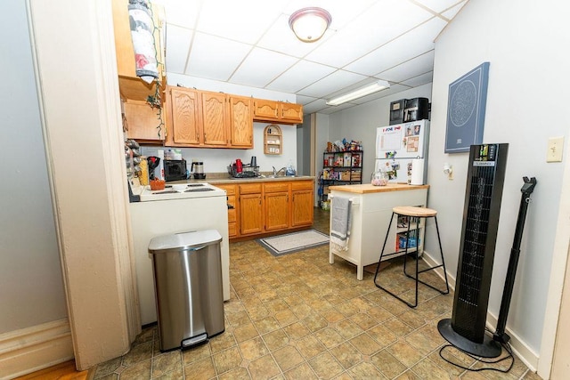 306 Wisconsin St, Oshkosh, WI 54901 - kitchen featuring light countertops, a heating unit, a drop ceiling, a sink, and freestanding refrigerator