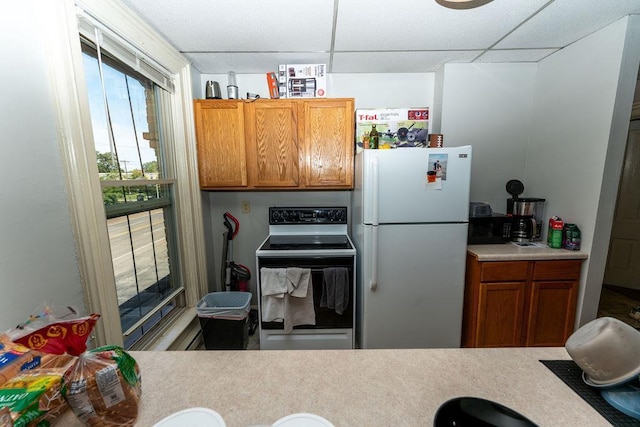 306 Wisconsin St, Oshkosh, WI 54901 - kitchen featuring freestanding refrigerator, electric range, a paneled ceiling, light countertops, and brown cabinetry