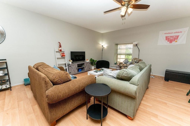 306 Wisconsin St, Oshkosh, WI 54901 - living room featuring light wood-style flooring, ceiling fan, a baseboard radiator, and baseboards