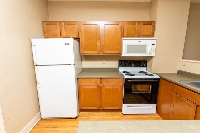 306 Wisconsin St, Oshkosh, WI 54901 - kitchen with white appliances, light wood-style flooring, and brown cabinetry